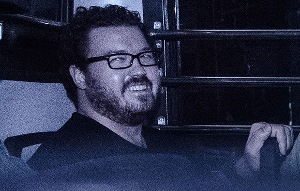 British banker Rurik Jutting, charged with the grisly murders of two women, smiles as he sits in a prison van leaving the eastern court in Hong Kong on November 10, 2014.