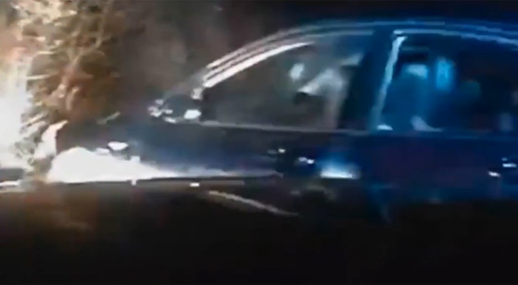 The chase begins on residential roads surrounded by houses and parked cars before Ross heads into lanes in an attempt to escape the police car