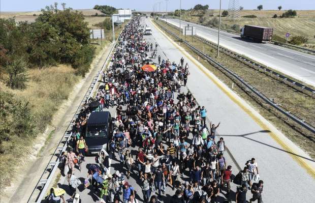Syrian migrants and refugees march along