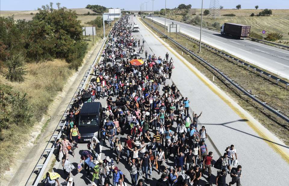 Syrian migrants and refugees march along