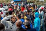 Migrants queue to get food at a site dub