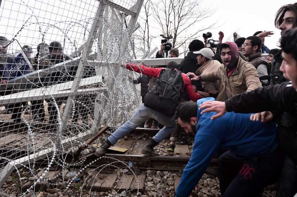 Migrants try to break through a border f