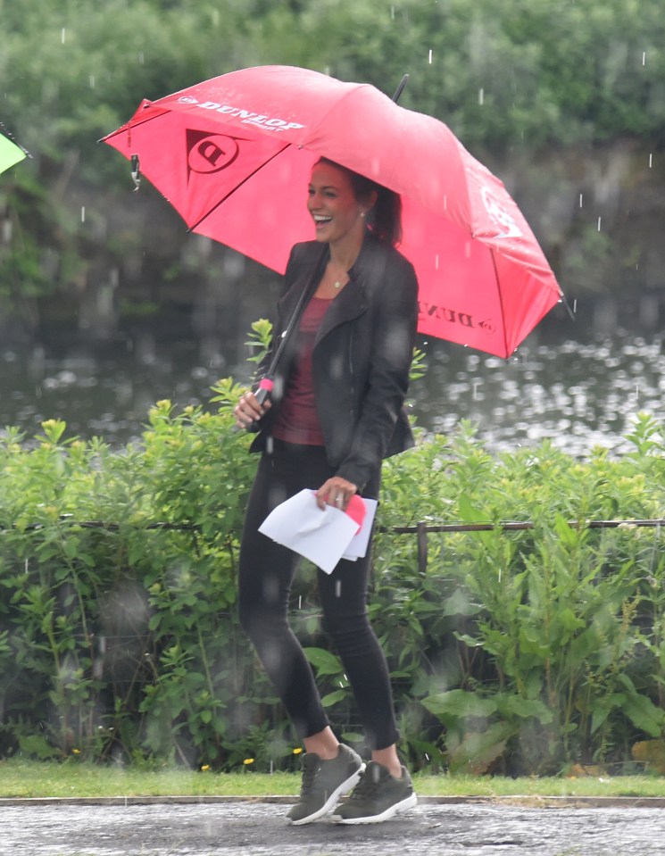 Michelle looking jolly with her brolly during heavy rain 