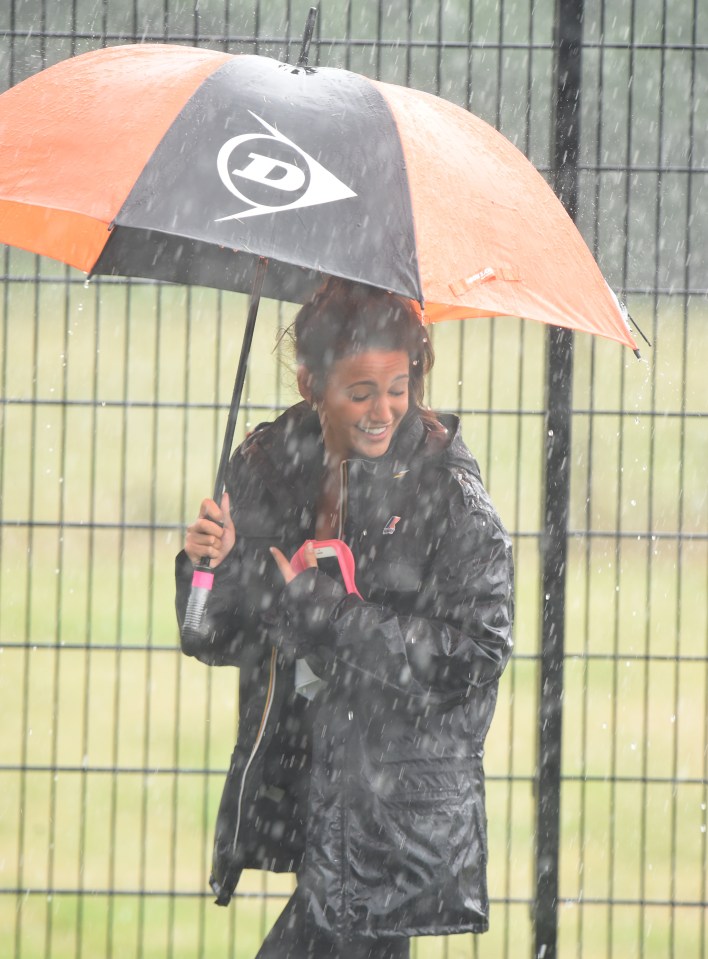 The downpour stopped the filming but didn't dampen the mood as Corrie star is snapped laughing in the rain