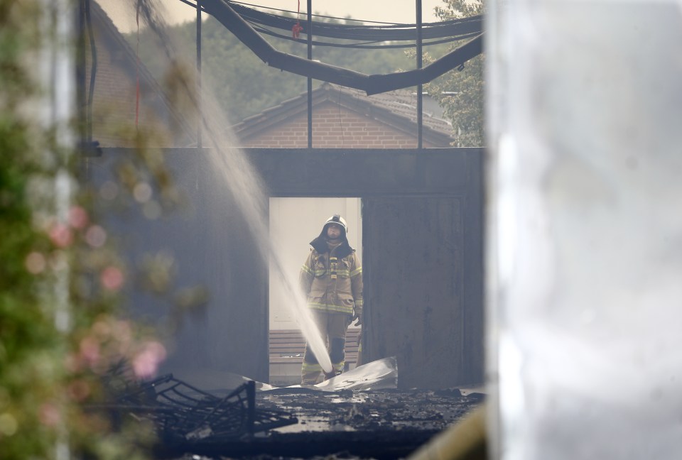 A firefighter extinguishes fire at fair halls used as refugee camps in Duesseldorf