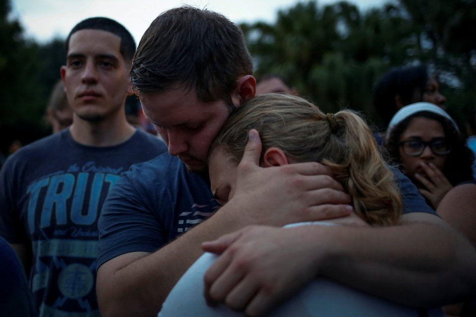 Friends embrace during a vigil to commerate victims of a gay night club shooting in Orlando, Florida