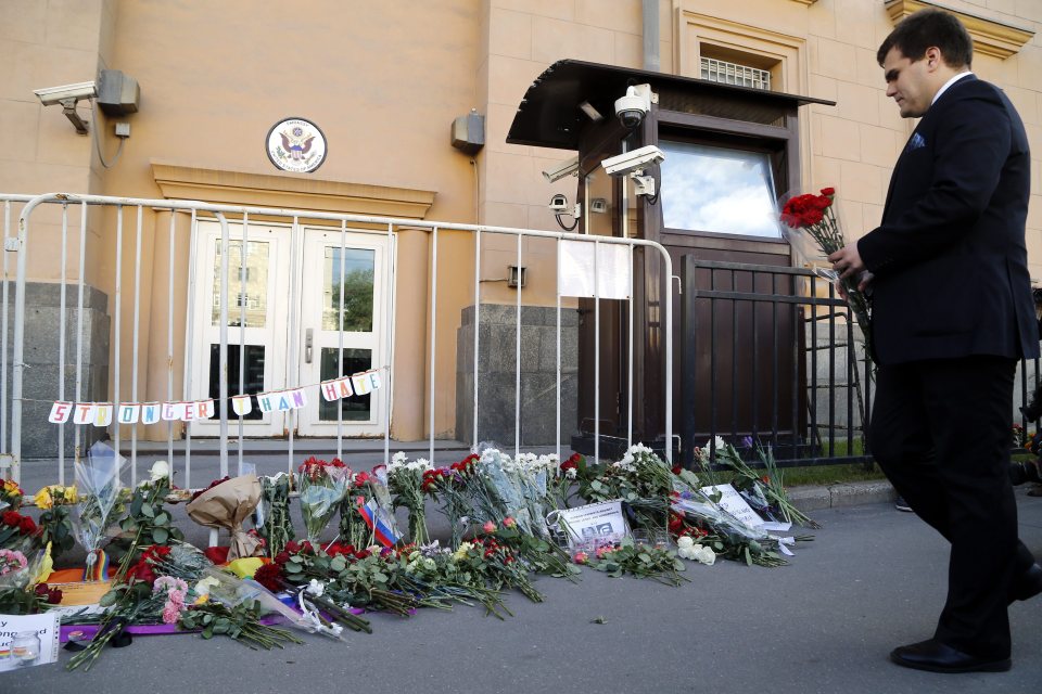 Prayers ... Russian man leaves flowers in small tribute outside US embassy in Moscow
