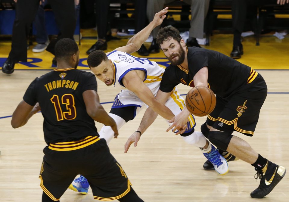 Cleveland Cavaliers' forward Kevin Love (R) goes for loose ball against Golden State Warriors' guard Stephen Curry (C)