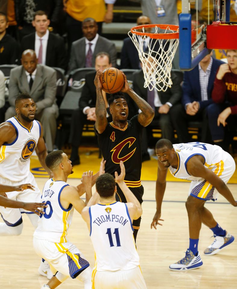 Cleveland Cavaliers guard Iman Shumpert (centre) shoots the ball over Golden State Warriors guards Stephen Curry (second left) and Klay Thompson (11) during the second quarter of game five of the NBA Finals