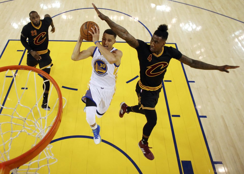 Cleveland Cavaliers' forward LeBron James (L) and guard Iman Shumpert (R) try to block a shot against Golden State Warriors' guard Stephen Curry (C) during the first half of the NBA Finals game five between Cleveland Cavaliers and Golden State Warriors