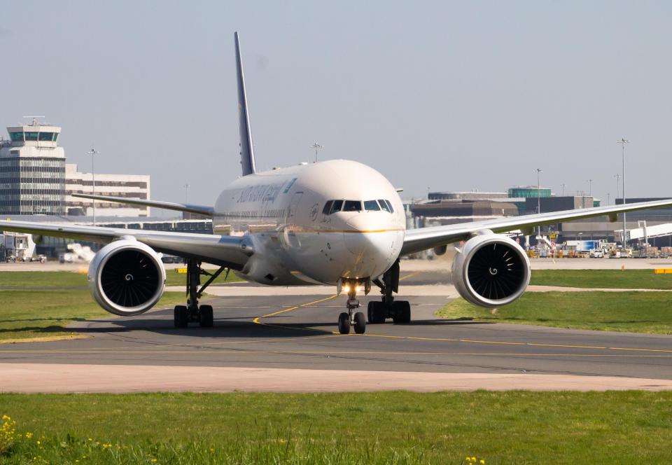 Saudi Arabian Airlines Boeing 777, taxiing in front of Manchester International Airport terminal.