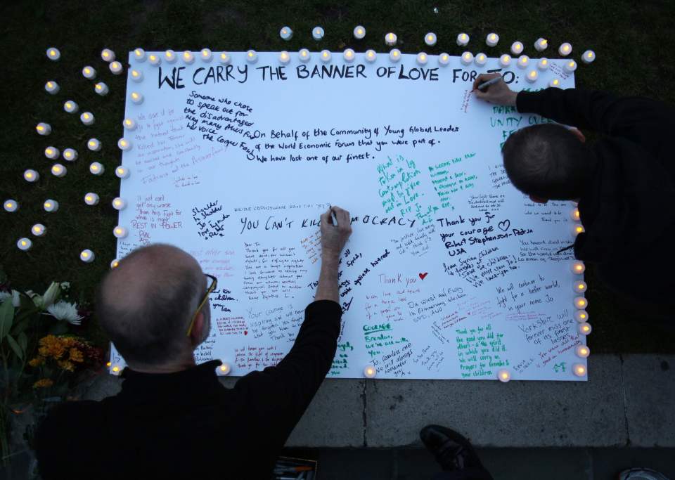 Members of the public sign a white board