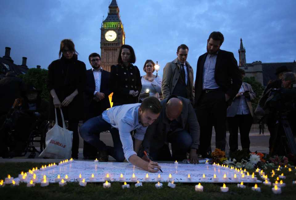 Members of the public sign a white board
