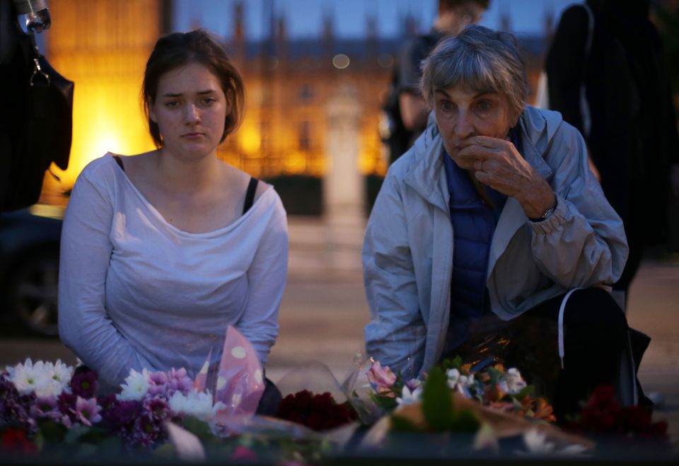 People place floral tributes and candles
