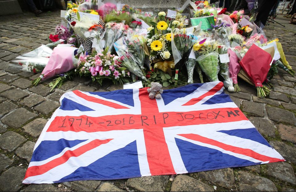 A Union Jack flag lies in front of floral tributes in Birstall, West Yorkshire where Mrs Cox was an MP while tributes are also held in Parliament Square, London where she represented her constituents