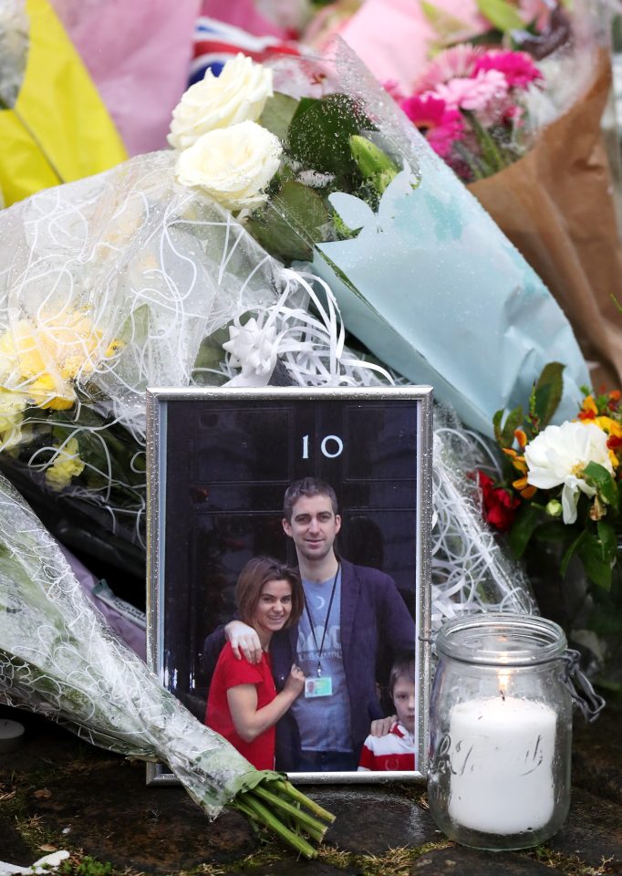 A framed photograph of Jo Cox and her husband Brendan standing outside 10 Downing Street is placed alongside floral tributes as people pay their respects near to the scene of the murder 