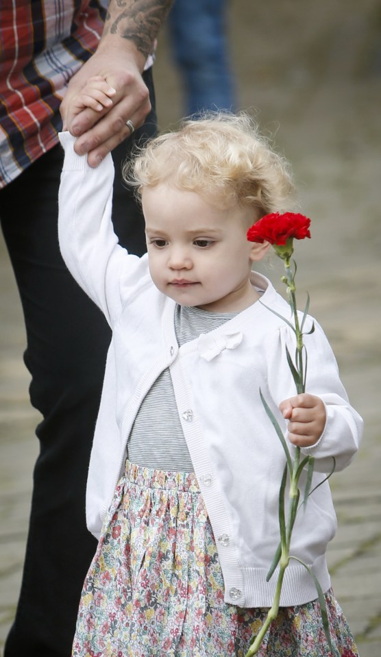 A little girl leaves a single red rose for murdered Jo Cox