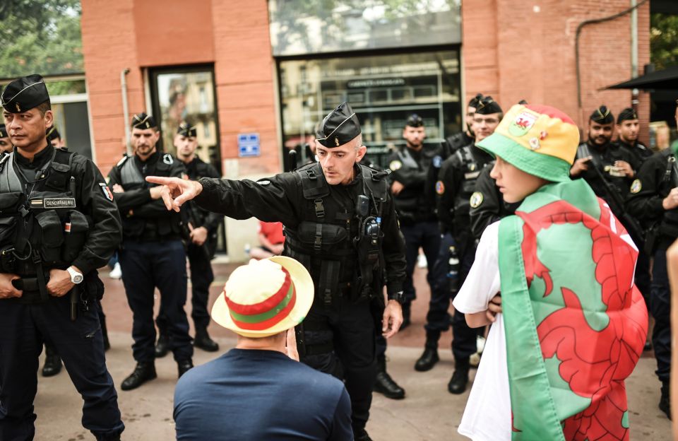 A French gendarm talks with Wales' suppo