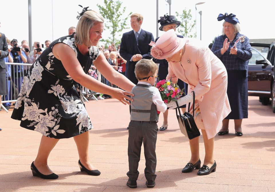 Lewis Connet hands the Queen a bunch of flowers on her visit to Alder Hey Children's Hospital