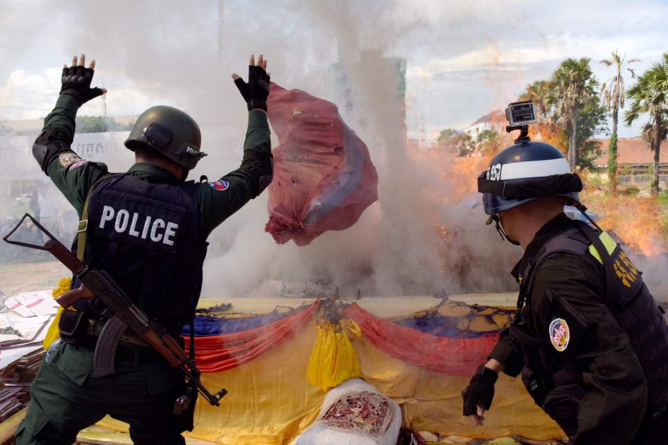 Cambodian police officials throw drugs 