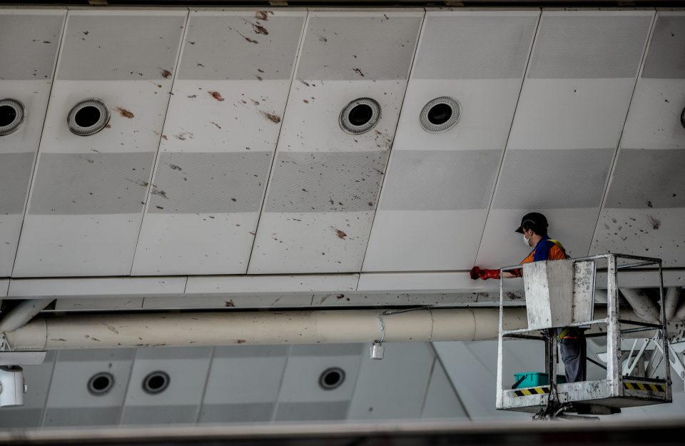 A worker cleans the blood splashed on the roof of the international departure terminal at the country's largest airport