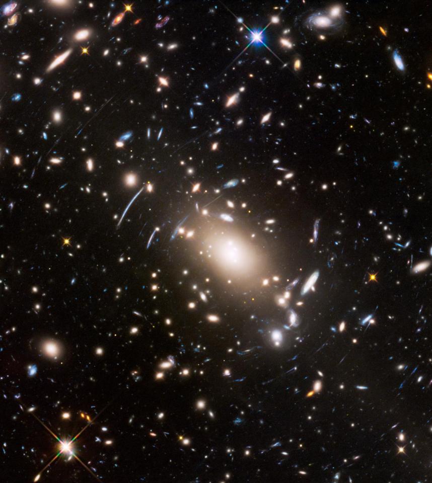 NASA says this view show 'a massive cluster of galaxies unveils a very cluttered-looking universe filled with galaxiesnear and far'