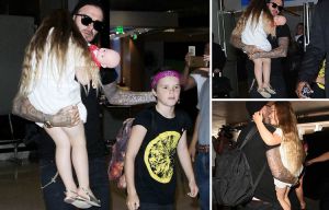 Devoted dad David Beckham carries a sleepy Harper as he jets in to LA with his daughter and youngest son Cruz