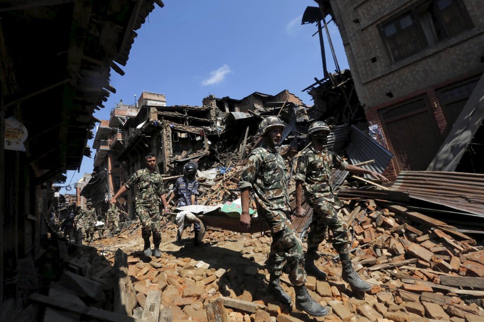 Nepalese army personnel carry a dead body recovered from the rubble of a damaged house following Saturday's earthquake, in Bhaktapur, Nepal