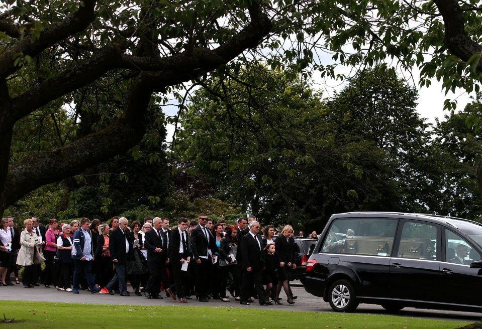 Mourners walk behind a hearse carrying Lamara Bell's coffin after her funeral