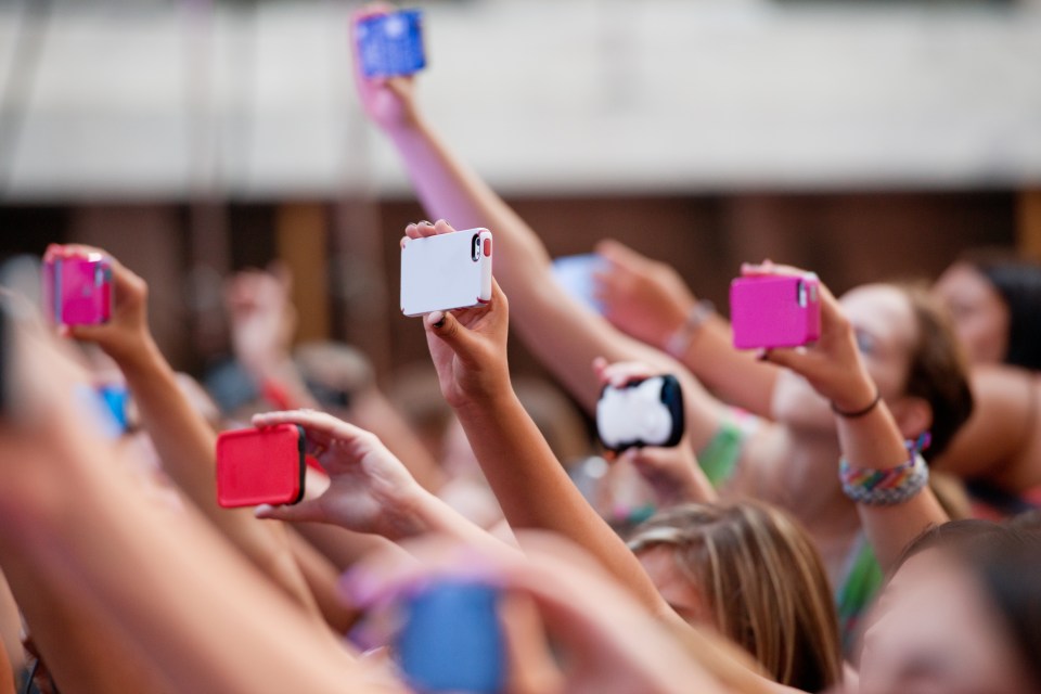 Crowd of people at a concert using mobile phones