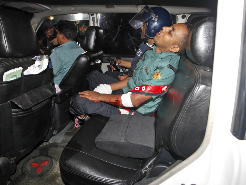 An injured police officer sits in a car following the deadly gun battle