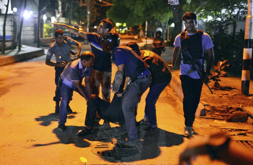People assist a person injured in the deadly shootout in Dhaka
