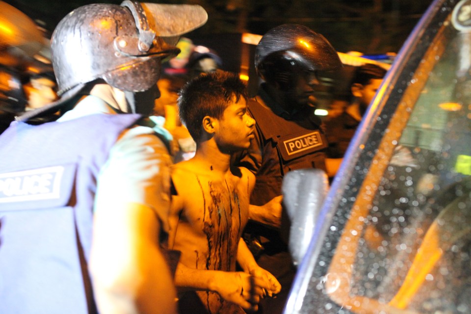 DHAKA, BANGLADESH - JULY 02: Bangladeshi police arrest a suspect who ran over from hotel injured with bullet on July 2, 2016 in Dhaka, Bangladesh. Multiple foreigners are being held hostage by eight or nine gunmen at O'kitchen restaurant, in the same building as the the Holey Artisan Bakery cafe - a location popular with expatriates and diplomats. A gun battle between the attackers and police wounded three people, including two officers. Police and security forces have sealed off the area in the city's Gulshan district and are trying to negotiate a hostage release. PHOTOGRAPH BY Zakir Chowdhury/Barcroft Images London-T:+44 207 033 1031 E:hello@barcroftmedia.com - New York-T:+1 212 796 2458 E:hello@barcroftusa.com - New Delhi-T:+91 11 4053 2429 E:hello@barcroftindia.com www.barcroftimages.com