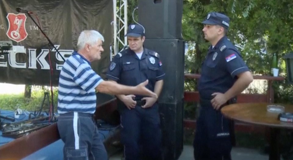 A man talks to police officers at the scene after 5 people were gunned down and 20 others hospitalised 