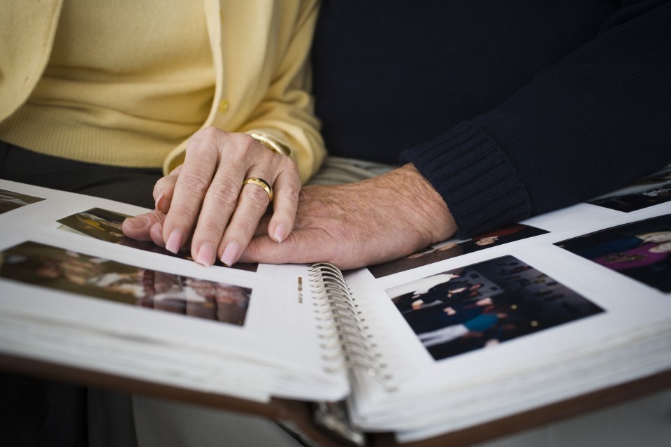 Mid section view of a couple looking at a photo album