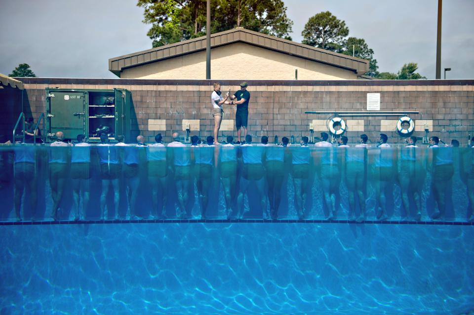 U.S Navy SEALs sink to the bottom of a pool with their hands and feet bound during drown proofing exercises at the Naval Special Warfare Center June 23, 2012 in San Diego, CA.