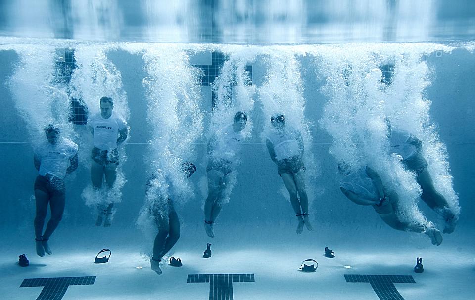 U.S Navy SEALs sink to the bottom of a pool with their hands and feet bound during drown proofing exercises at the Naval Special Warfare Center June 23, 2012 in San Diego, CA.
