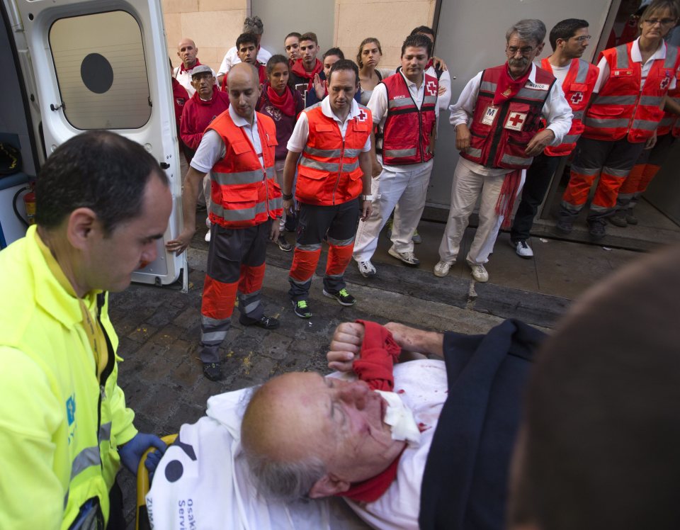 An unidentified runner is taken away for treatment after suffering cuts and bruises during the bull run