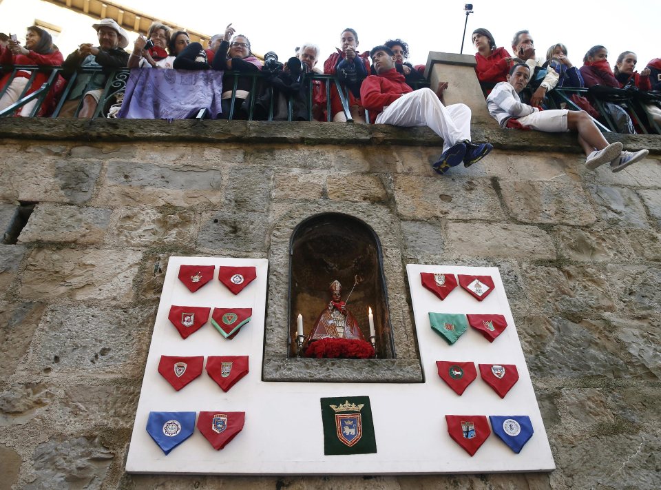 A view of the St. Fermin statue (centre) in its niche before the race with the runners saying a prayer to the statue to keep them safe