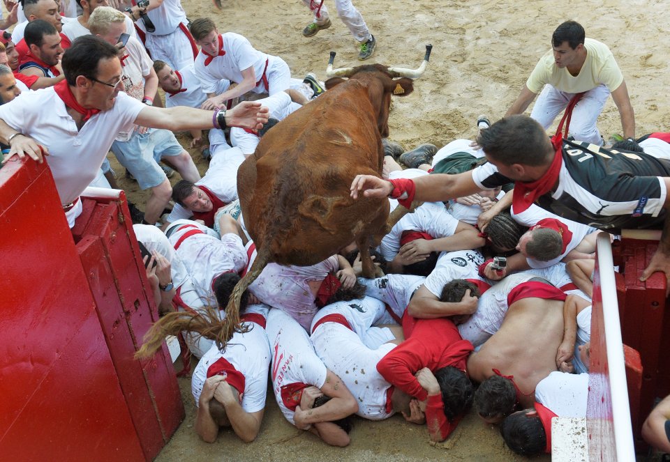 A wild cow jumps over the runners in the first day of the festival, which saw four people injured