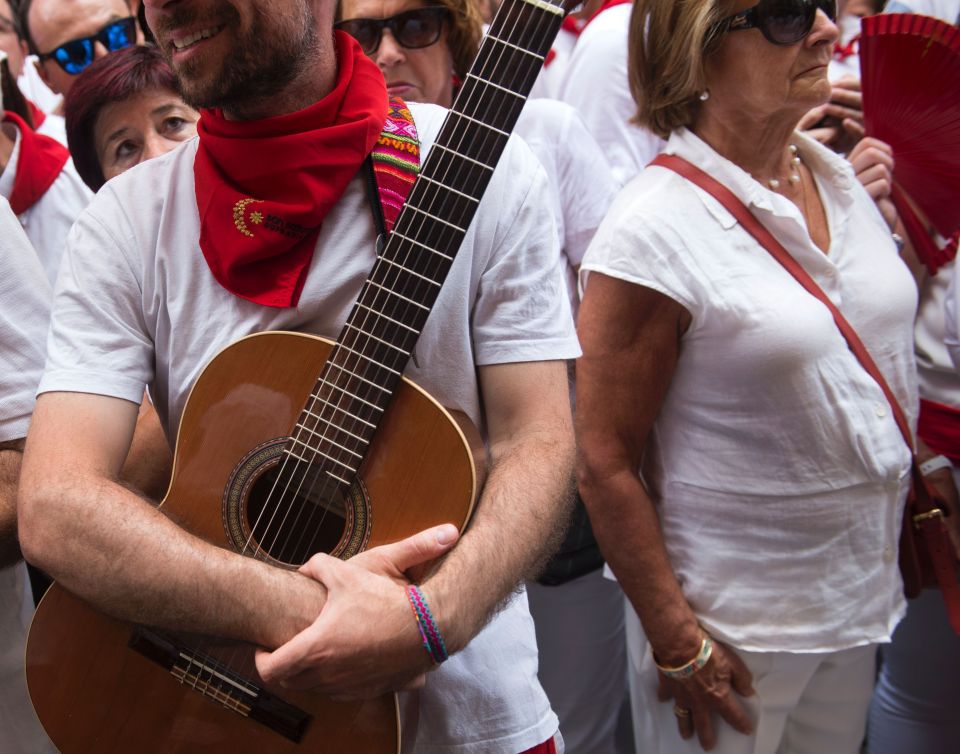 People wait for the procession in the centre of Pamplona after the first running of the bulls through the streets 