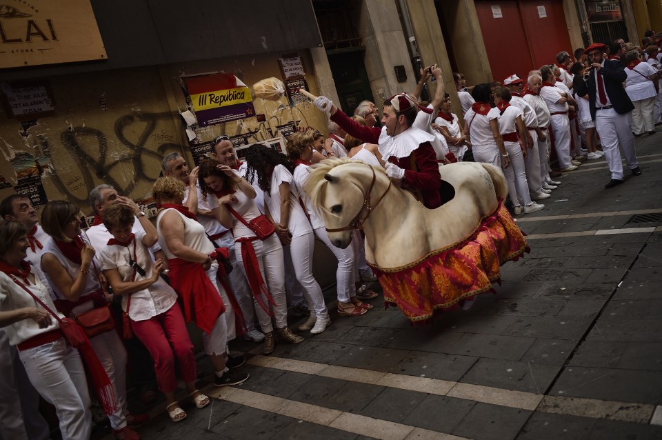 A Zaldiko, a member of the San Fermin Comparsa Parade dressing as a horse, dances on the street 