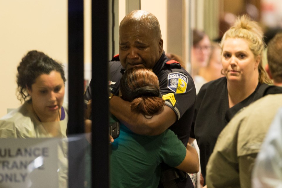 A Dallas police officer weeps after the devastating news is broken