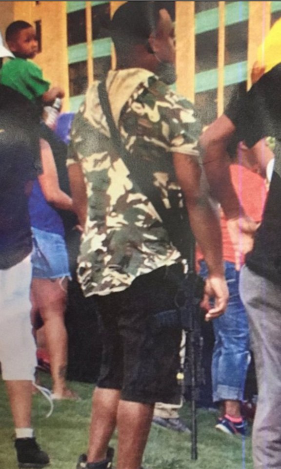 Mark Hughes pictured carrying an AR-15 assault rifle at the rally