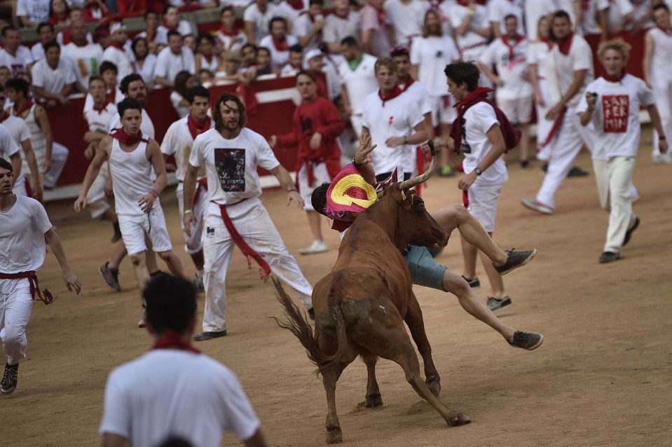 A reveller is pushed down by a bull during the second run, which took more than six minutes to end the race