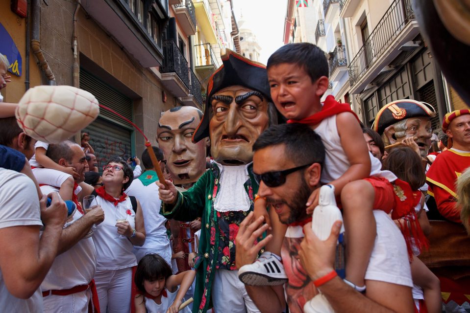 A child cries as the Caravinagre 'Vinegar face' kiliki parades down the street as part of the festival 