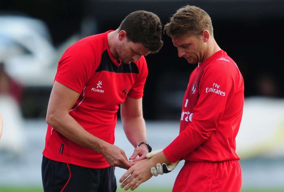 Jos Buttler has his thumb looked at by a physio during Twenty20 game