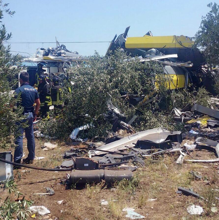 Metal pieces of debris lie scattered across the countryside following the deadly train crash in Italy
