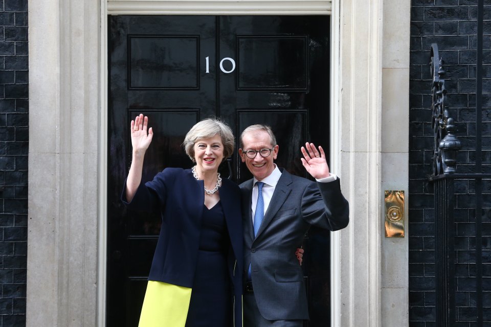 New Prime Minister Theresa May waves out the front of her new home with husband Philip May