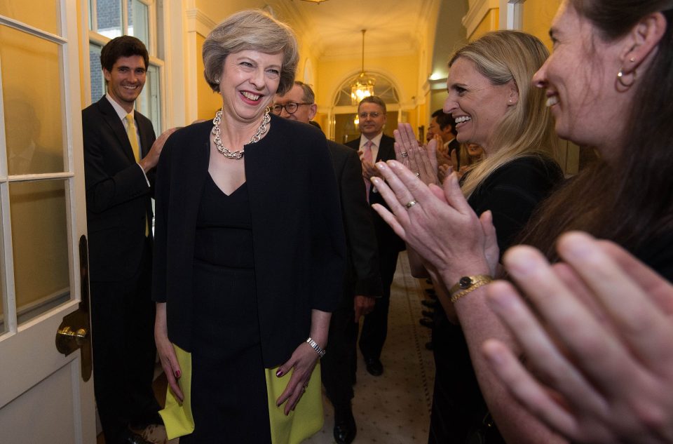 Theresa May grins at her No10 staff as she enters her new home